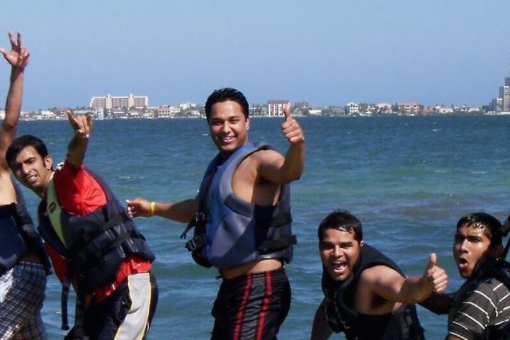 a group of people riding on the back of a boat in the water