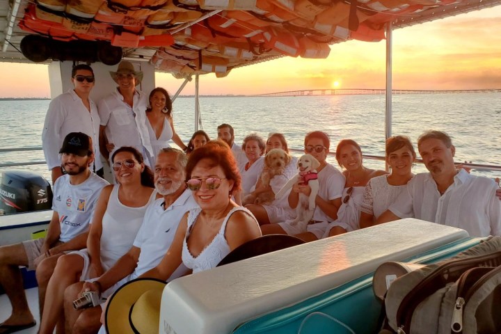 a group of people sitting in front of a body of water