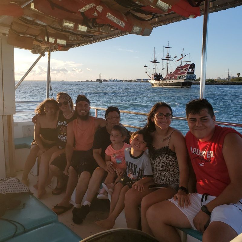 a group of people sitting in a boat on a body of water
