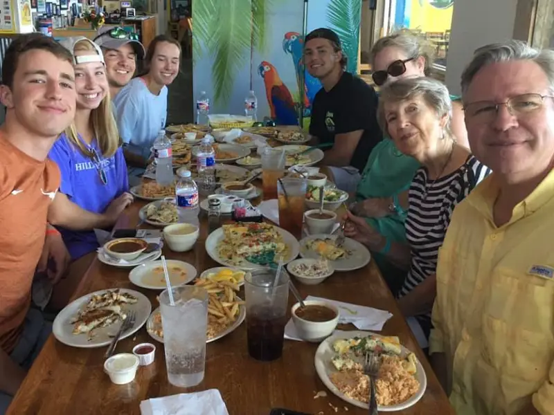 a group of people sitting at a table eating food