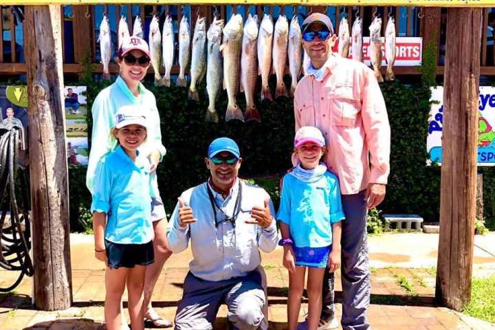 a group of people standing in front of a sign posing for the camera