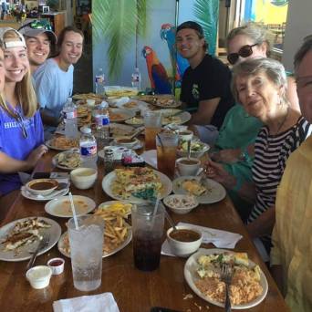 a group of people sitting at a table eating food