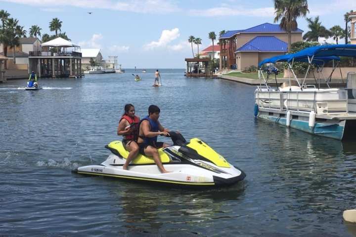 a group of people riding on the back of a boat in the water